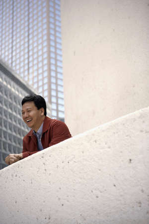Asian man on balcony of urban buildingの写真素材