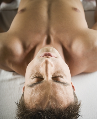 Close up of man laying on massage tableの写真素材