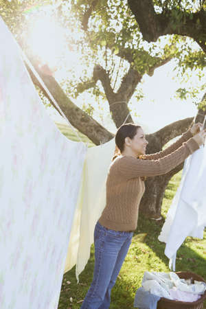 Hispanic woman hanging laundry on clotheslineの写真素材