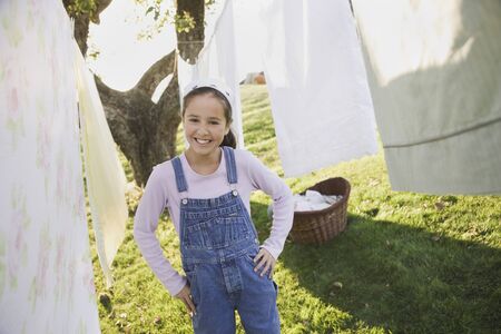 Pacific Islander girl smiling next to laundry on clotheslineの写真素材