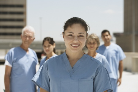 Hispanic female doctor smiling with co-workers in backgroundの写真素材