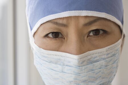 Close up of Asian female doctor wearing surgical maskの写真素材