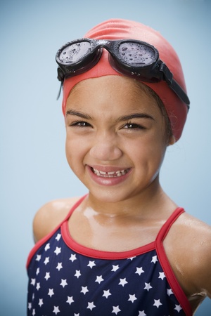 Hispanic girl in bathing suit with goggles and swim capの写真素材