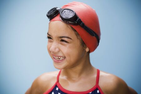 Hispanic girl in bathing suit with goggles and swim capの写真素材