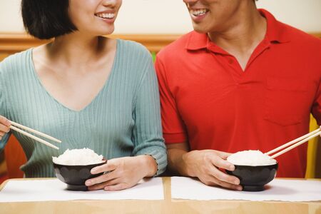 Asian couple eating riceの写真素材