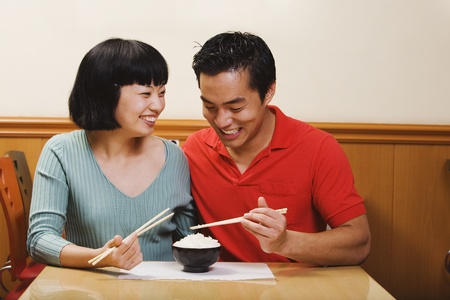 Asian couple eating riceの写真素材