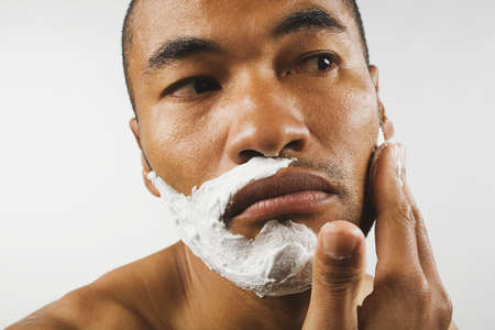 Asian man applying shaving creamの写真素材