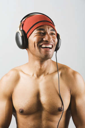 Asian man listening to headphonesの写真素材