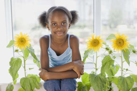 African girl sitting next to flowersの写真素材