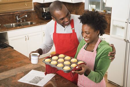 African American couple holding tray of muffinsの写真素材