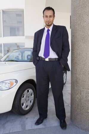 Hispanic car salesman next to new carの写真素材