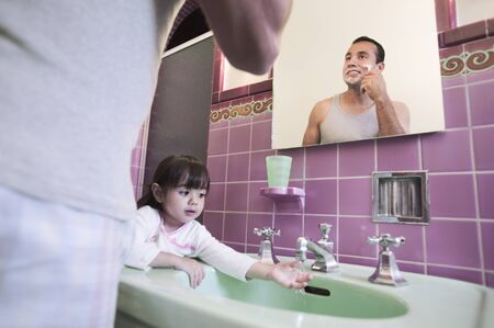 Father shaving with daughter at sink
