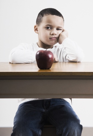 African boy at desk with appleの写真素材