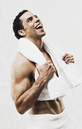 Mixed Race man in towel laughingの写真素材