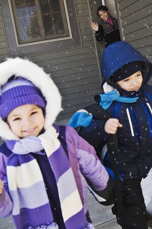 Mother sending children to school in winterの写真素材