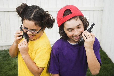Mixed Race children talking on walkie talkiesの写真素材