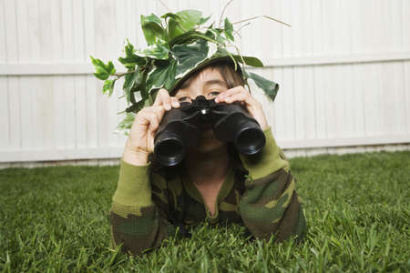 Mixed Race boy looking through binocularsの写真素材