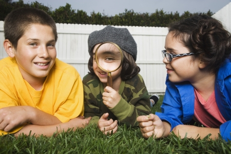 Mixed Race children playing with magnifying glassの写真素材