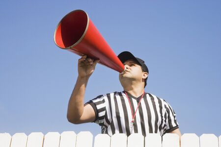 Hispanic referee yelling over fenceの写真素材