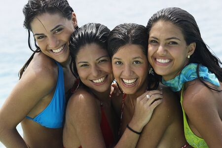 South American women hugging at beachの写真素材