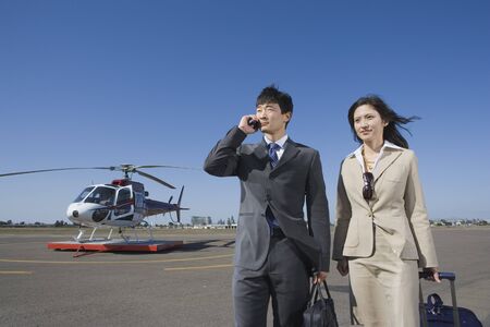 Asian businesspeople waking away from helicopterの写真素材