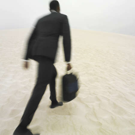 African businessman walking on beachの写真素材