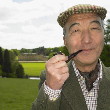 Senior Asian man smoking pipe