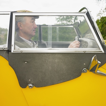 Senior Asian man driving old fashioned carの写真素材