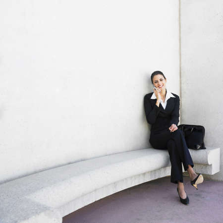 Hispanic businesswoman talking on cell phoneの写真素材