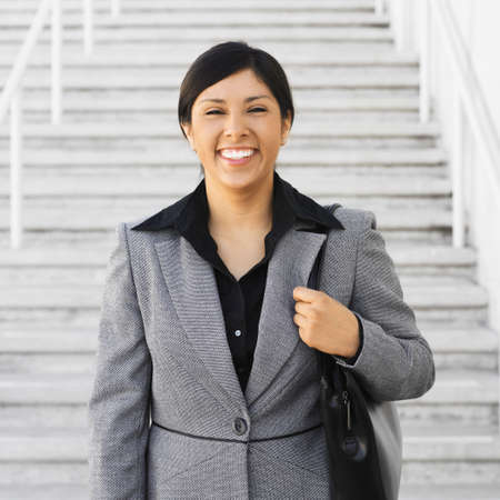 Hispanic businesswoman next to outdoor stairsの写真素材