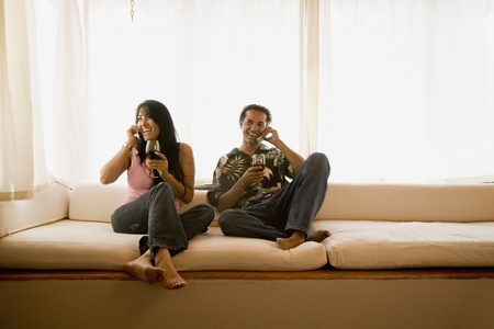 Hispanic couple talking on cell phonesの写真素材
