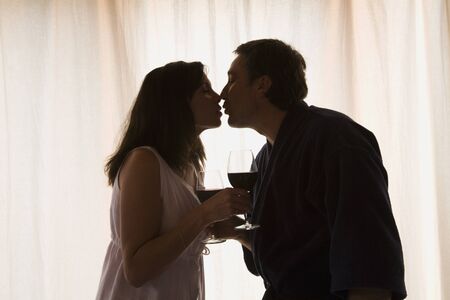 Hispanic couple kissing next to windowの写真素材