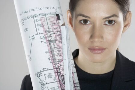 Close-up of a young woman holding blueprintsの写真素材