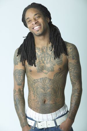 Portrait of a young man standing bare cheated with tattoosの写真素材
