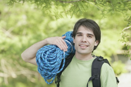 Man holding a bundle of climbing ropeの写真素材