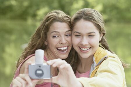 Women taking snapshots in a forestの写真素材