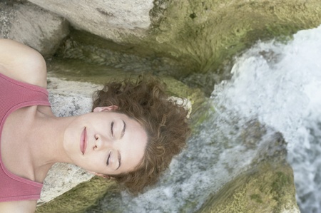 Woman resting her head on a rockの写真素材