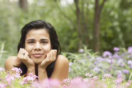 Portrait of a young woman lying in a gardenの写真素材