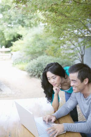 Mid adult man and a young woman working on a laptopの写真素材