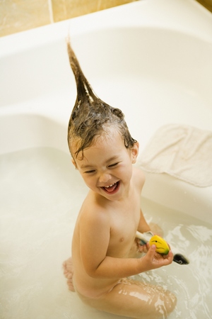 Girl playing in bathtub with funny hairの写真素材