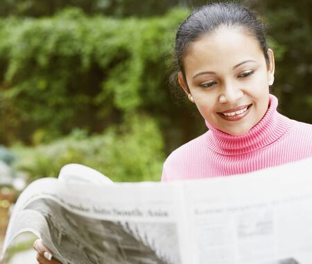 Young woman reading the newspaperの写真素材