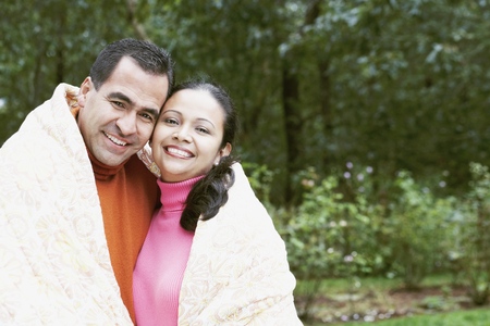 Couple wrapped in a blanket outdoorsの写真素材