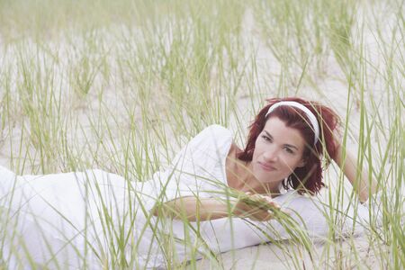 Young woman smiling for the camera on the beachの写真素材