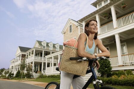 Woman riding a bike down suburban streetの写真素材