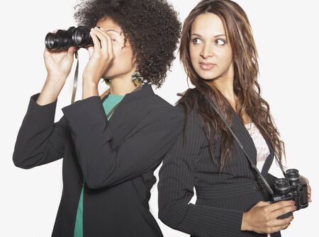 Businesswomen looking through binocularsの写真素材