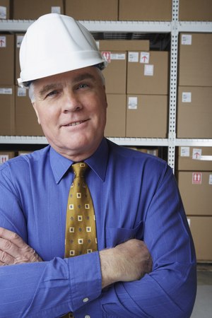 Businessman wearing hard hat in warehouseの写真素材