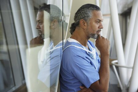 Middle-aged male African surgeon thinkingの写真素材
