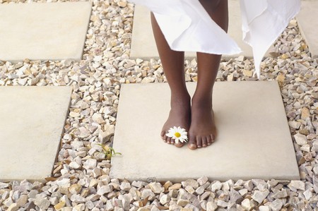Close up of African American woman's bare feet with flowerの写真素材