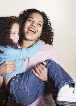 Mother carrying daughter and laughingの写真素材