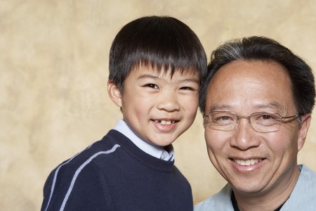 Asian father and young son smiling